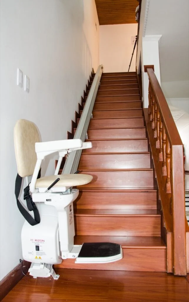 Silla salvaescaleras recta plegada al pie de una escalera residencial