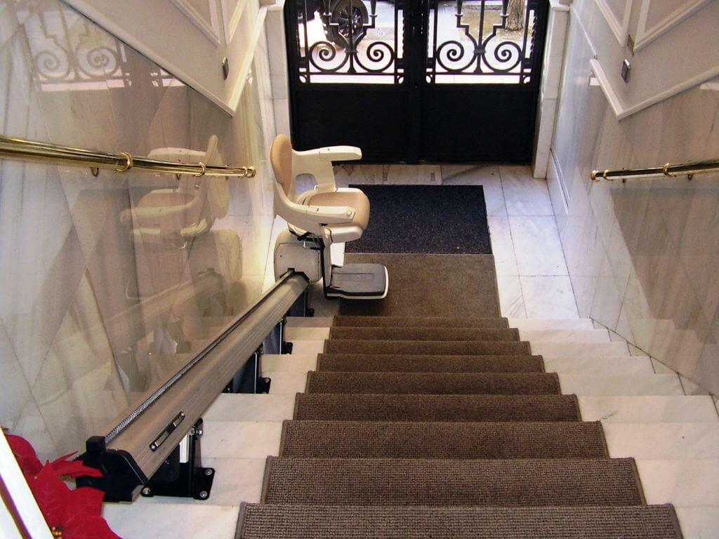 Silla salvaescaleras recta instalada en escalera de mármol de edificio