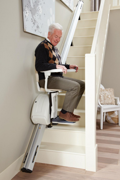 Silla salvaescaleras recta con usuario adulto mayor en escalera de madera